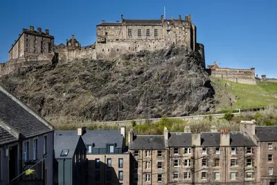 a castle on top of a hill with buildings at Castle Vista, Grassmarket Apartment in Edinburgh