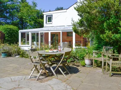 a patio with a table and chairs in front of a house at The Old Schoolhouse in Colfin