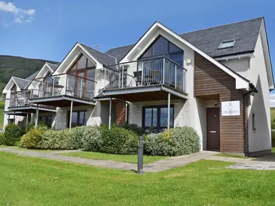 a large house with balconies on the side of it at The Bothy in Stron-fearnan