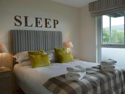 a bedroom with a bed with towels on it at The Bothy in Stron-fearnan