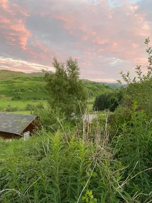 a house in the middle of a field with bushes at Lagnakeil Highland Lodges in Oban
