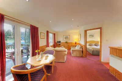 a living room with a table and chairs and a bedroom at Lagnakeil Highland Lodges in Oban