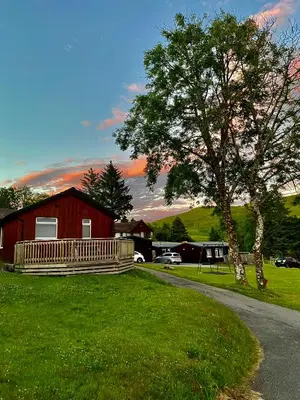 a house with a tree and a house with a driveway at Lagnakeil Highland Lodges in Oban