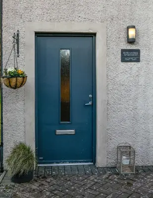 a blue door on the side of a building at Rowan Tree Apartment - Modern Apartment, Free Parking & Views in Oban