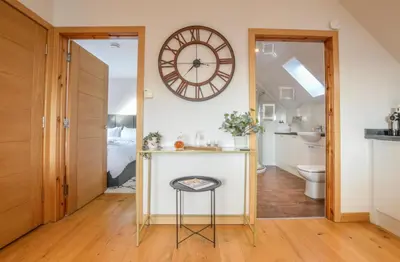 a bathroom with a counter and a clock on the wall at Rowan Tree Apartment - Modern Apartment, Free Parking & Views in Oban