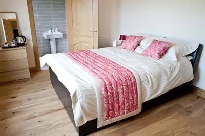 a bedroom with a large bed with pink pillows at Bamflatt Farm Bed & Breakfast in Strathaven