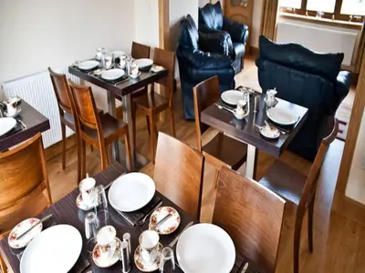 a dining room with tables and chairs with dishes on them at Bamflatt Farm Bed & Breakfast in Strathaven