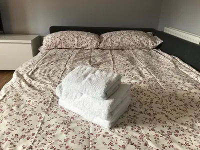 a bed with two towels sitting on top of it at Flat One, 212 Eaglesham Road, East Kilbride, Glasgow in Glasgow