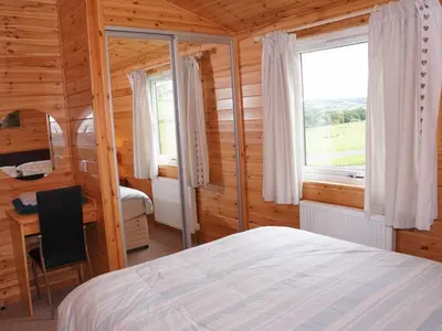 a bedroom with a bed and a desk and a window at Chalet Osprey Lodge by Interhome in Kinross