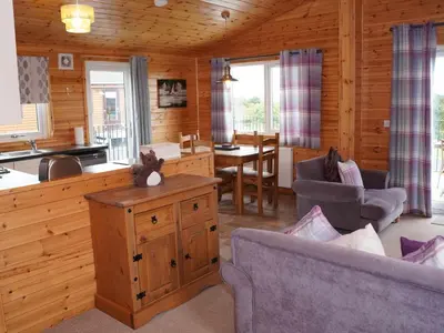 a kitchen and living room in a log cabin at Chalet Osprey Lodge by Interhome in Kinross