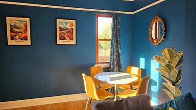 a dining room with blue walls and a table and chairs at Beautiful self contained apartment with garden in Glasgow