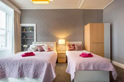 a bedroom with two beds with red pillows on them at Stunning 2-Bed Apartment in Central Edinburgh in Edinburgh