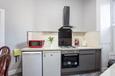 a kitchen with a stove and a microwave at Stunning 2-Bed Apartment in Central Edinburgh in Edinburgh