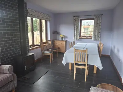 a dining room with a table and chairs and a fireplace at Rockfoot B&B in Fintry