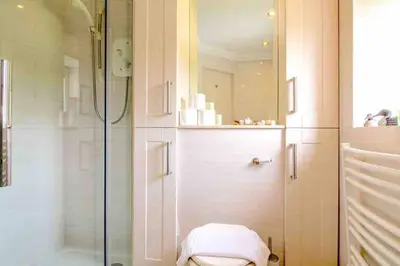 a bathroom with a shower and a toilet and a glass door at 45 Guthrie Court, Fantastic top floor apartment next to Gleneagles in Auchterarder