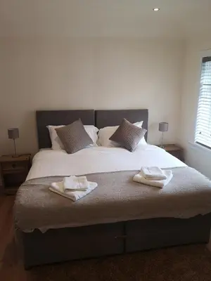 a bedroom with a large bed with two towels on it at Arrochoile Cottage in Glasgow