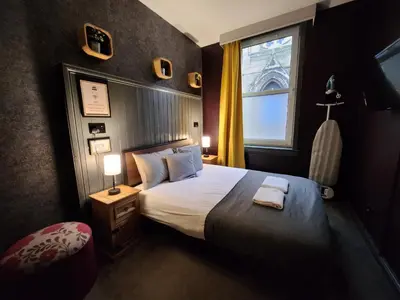 a bedroom with a large bed and a window at Frederick Douglass - Rooms In The City in Edinburgh