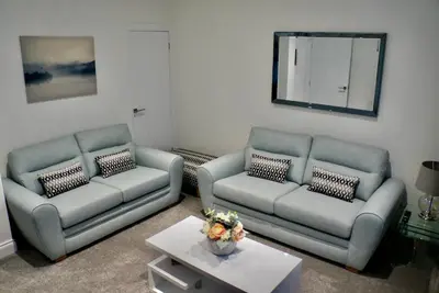 a living room with two couches and a mirror at Leworin in Stirling