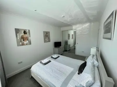 a white bedroom with a bed and a tv at Leworin in Stirling
