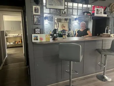 a woman sitting at a counter in a bar at Dellwood Hotel in Campbeltown