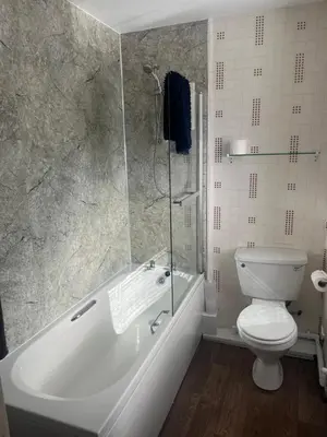 a bathroom with a tub and a toilet and a shower at Dellwood Hotel in Campbeltown
