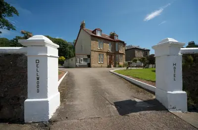 a house with a gate in front of a street at Dellwood Hotel in Campbeltown