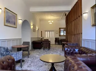 a living room with couches and tables and chairs at Argyll Arms Hotel in Campbeltown