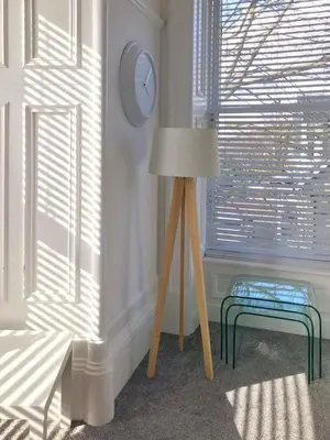 a room with a lamp and a bench and a clock at Bishopton Apartment, near Glasgow in Bishopton