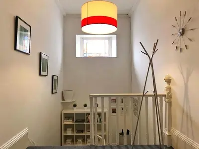 a room with a staircase and a clock on the wall at Bishopton Apartment, near Glasgow in Bishopton