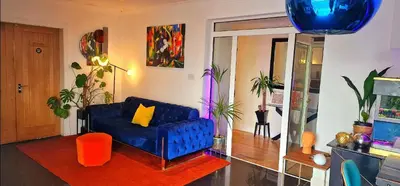 a living room with a blue couch with a yellow pillow at The Sleeping Dog Room at The Grumpy Schnauzer BnB Huge Room, Luxe Suite, Private Hot Tub, Breakfast, Gym, Games Room, Farm Stay, Amazing in Airdrie