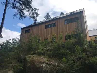 a building with windows on the side of it at Red Stag with stunning loch and waterfall view in Crianlarich