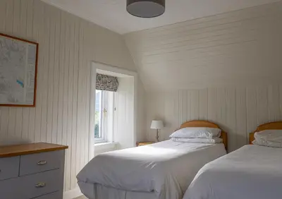 a bedroom with two beds and a window at Duart Cottage in Glencoe