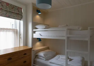 a room with three bunk beds and a desk at Duart Cottage in Glencoe