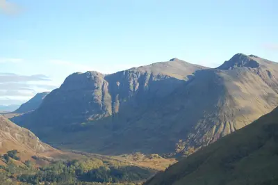 a view of a mountain range with trees in the foreground at Duart Cottage in Glencoe