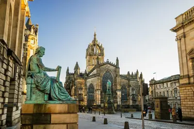 a statue of a woman in front of a cathedral at Stylish & Charming Retreat for 2- City Centre! - Pass the Keys in Edinburgh