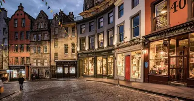 a street in an old city with stores at Stylish & Charming Retreat for 2- City Centre! - Pass the Keys in Edinburgh