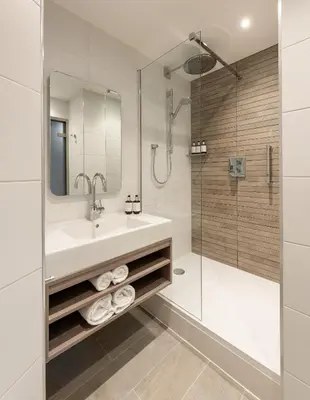 a bathroom with a sink and a shower at voco Edinburgh - Haymarket by IHG in Edinburgh