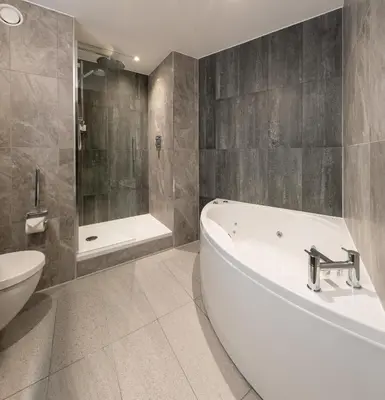 a bathroom with a tub and a toilet and a sink at voco Edinburgh - Haymarket by IHG in Edinburgh