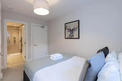 a bedroom with a bed and a picture of a deer on the wall at Dragon Suites - Edinburgh City Centre 2 Bed Apartment in Edinburgh