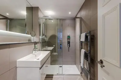 a bathroom with a shower and a sink and a toilet at Dragon Suites - Edinburgh City Centre 2 Bed Apartment in Edinburgh