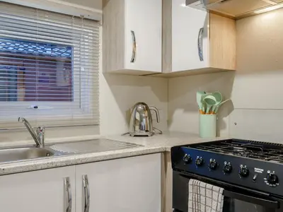 a kitchen with a sink and a stove top oven at The Paddocks - Uk7112 in Alloa