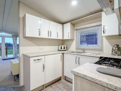 a kitchen with white cabinets and a counter top at The Paddocks - Uk7112 in Alloa