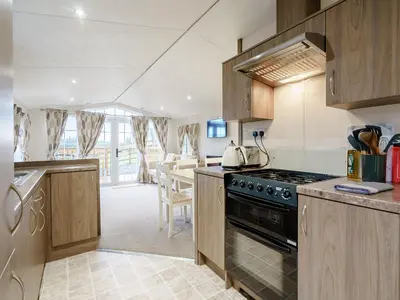 a kitchen with wooden cabinets and a stove top oven at The Orchard - Uk7111 in Alloa