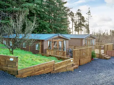 a wooden cabin with a fence and a yard at The Orchard - Uk7111 in Alloa