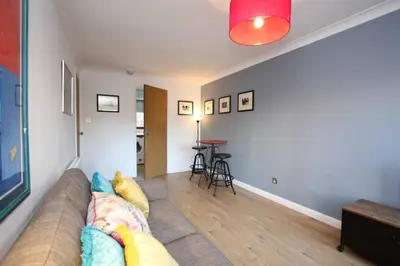 a living room with a couch and a table at Bijou Merchant City Apartment with Parking (Albion 1) in Glasgow