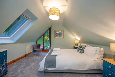 a bedroom with a bed and a window at Seabank Lochside Farmhouse in Oban