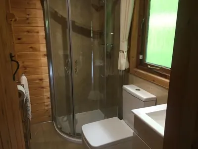 a bathroom with a shower and a toilet and a sink at Chalet 2 in Tyndrum