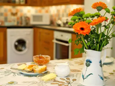 a vase with orange flowers sitting on a table at The Bothy in Haywood