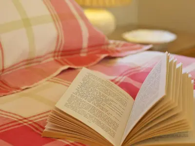 an open book sitting on top of a bed at The Bothy in Haywood
