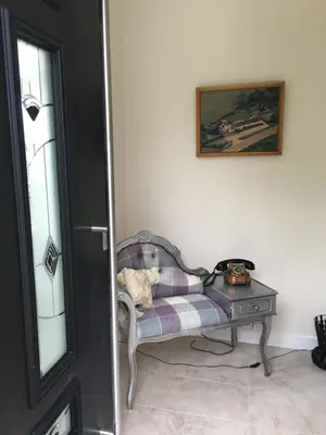 a living room with a chair and a table at Ben Lomond Cottage in Gartocharn
